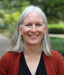 Dr. Kate Flory, a white woman with shoulder length grey hair, smiles at the camera.