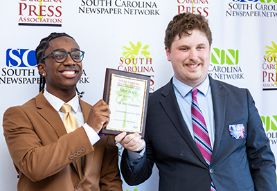 Leathers and Shea holding a plaque.