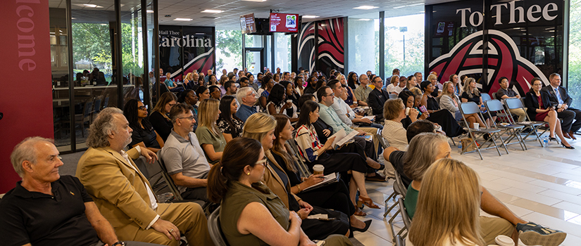 Faculty and staff from the College of HRSM sitting and listening at an all-college meeting