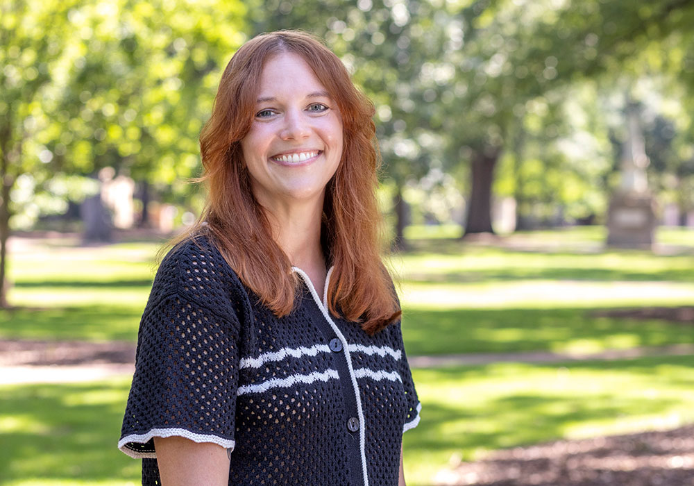 Vanessa Kitzie smiles wearing a short sleeved shirt on the sunny USC Horseshoe