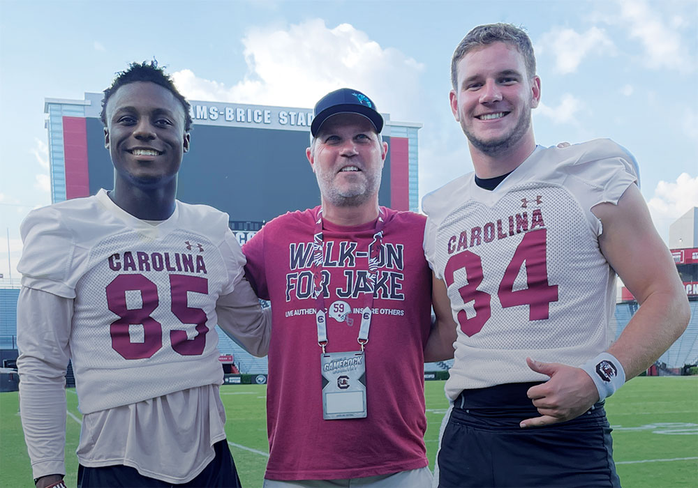 Stephen Panus, center, poses with the 2022 scholarship winner, wide receiver Payton Mangrum (left), and the 2021 winner, long snapper Matthew Bailey.