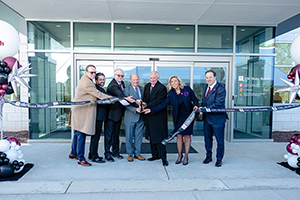 officials cutting a ribbon in front of a center