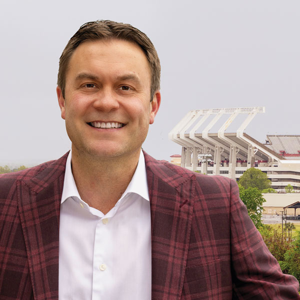 Jeremiah Donati smiles for the camera with Williams-Brice stadium in the background.