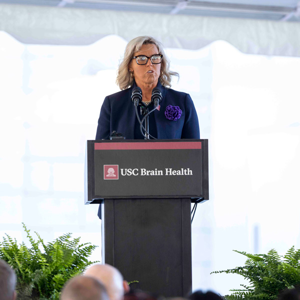 A woman stands behind a podium giving a speech.