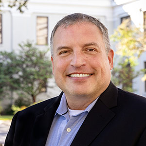Head and shoulders photo of Chris Burkett in front of USC College of Education