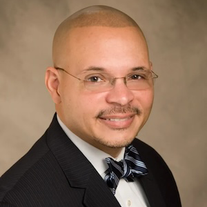 man wearing black suit and blue bow tie smiling