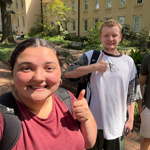 Corin Castro stands with another student on campus